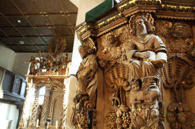 Blick auf die Kanzel, die die vier Apostel zeigt (rechts), und den Altar (links) der Postersteiner Burgkirche.