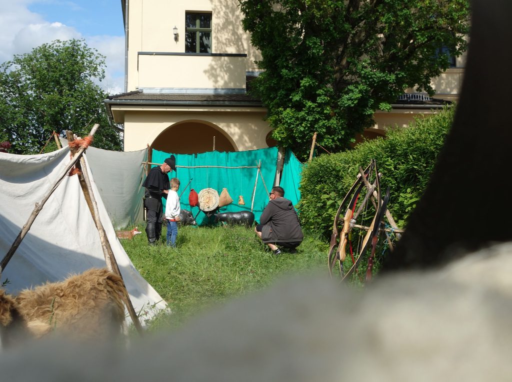 Junge lernt unter Anleitung Bogenschießen