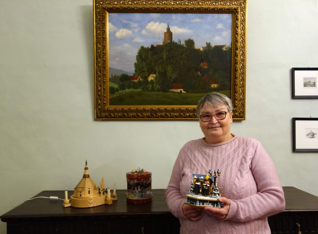 Christina Göldner mit drei ihrer weihnachtlichen Spieluhren im Museum Burg Posterstein
