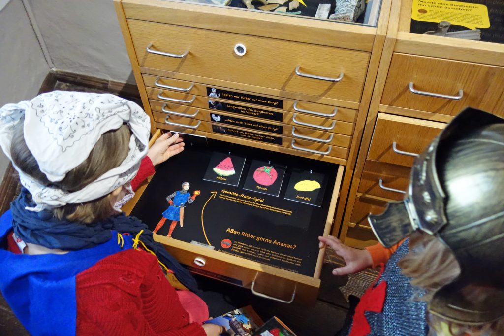 Kinder probieren die Familien-Ausstellung "Die Kinderburg" aus