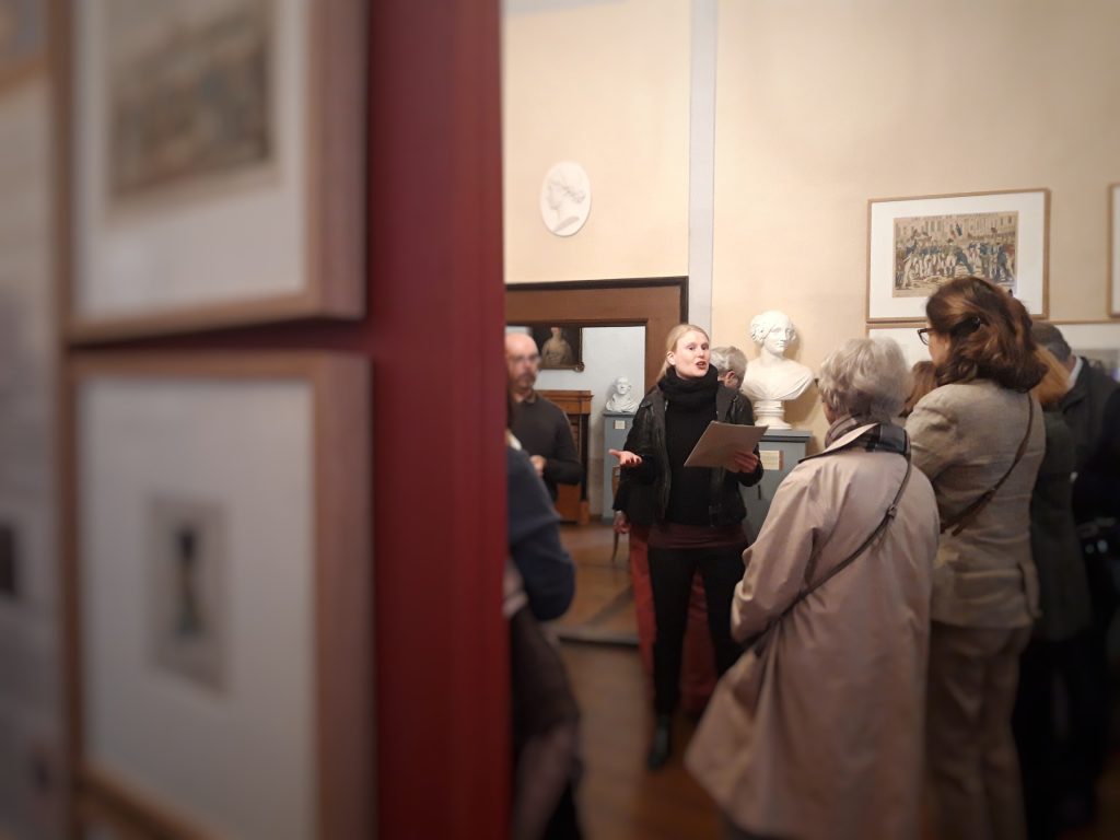 Eine Gruppe Besucher in den Rääumen der Burg Posterstein und in der Mitte eine junge Frau, die zur Geschichte der Herzogin von Kurland erzählt.