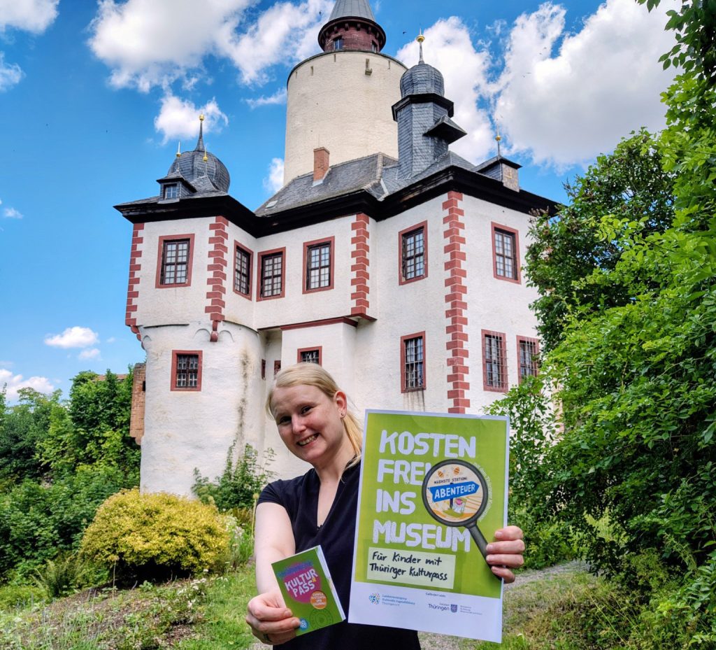 Junge Frau hält Kulturpass-Plakat in der Hand